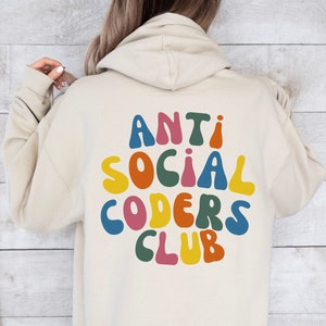 May include: A beige hoodie with the text "ANTI SOCIAL CODERS CLUB" in colourful, rounded letters on the back.