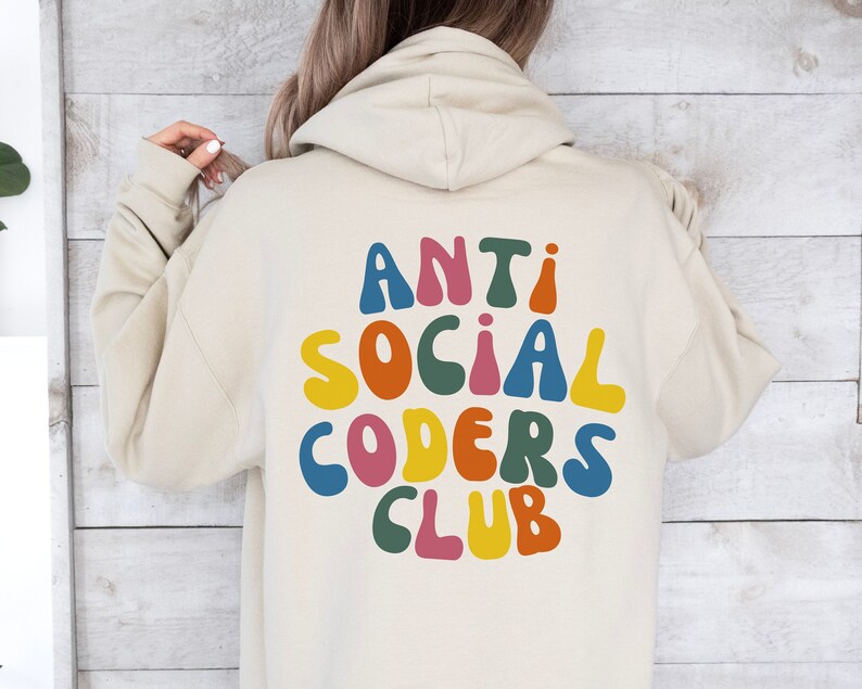 May include: A beige hoodie with the text "ANTI SOCIAL CODERS CLUB" in colourful, rounded letters on the back.