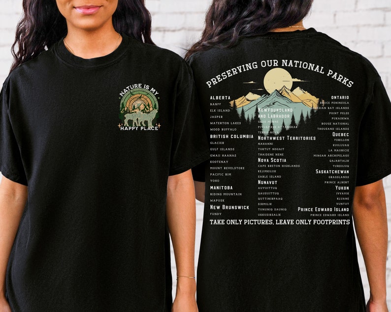 May include: Black t-shirt with a graphic of a forest scene and the text "Nature is my happy place". The back of the shirt has a list of Canadian national parks and the text "Preserving our national parks. Take only pictures, leave only footprints."