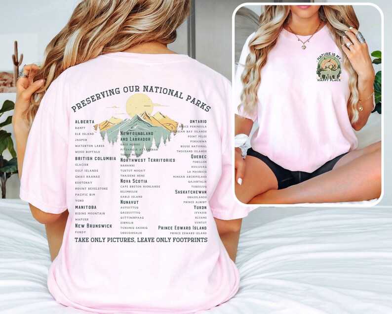 May include: Pink t-shirt with a graphic of mountains and trees, and the text "Preserving Our National Parks" and a list of national parks in Canada. The text "Take Only Pictures, Leave Only Footprints" is at the bottom of the graphic. The back of the shirt has a graphic of a mountain with a tree and the text "Nature is my happy place".