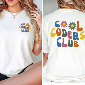May include: White t-shirt with a colourful graphic that says "Cool Coders Club" with flowers. The graphic is on the front of the shirt and the back of the shirt.