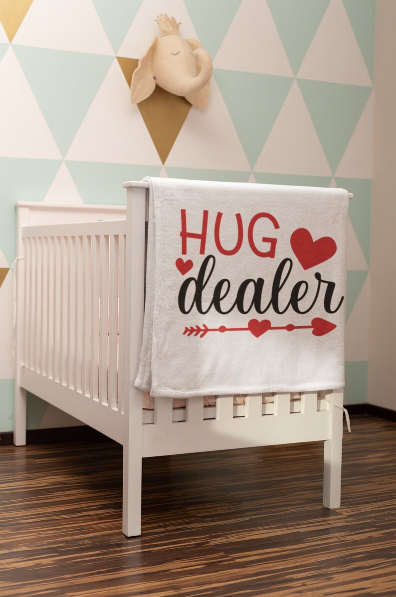 May include: White baby blanket with red hearts and the text "HUG dealer" in black lettering.