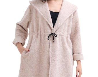 May include: A long-sleeved, hooded, beige cardigan with a drawstring at the waist. The cardigan has a soft, fuzzy texture.