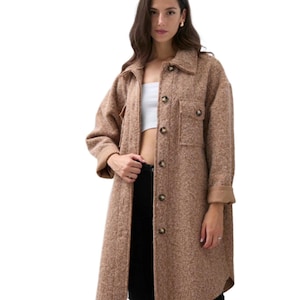 May include: A long brown button-up coat with a patch pocket on the left side. The coat has a slightly oversized fit and a relaxed silhouette.