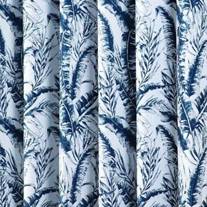 Könnte beinhalten: Weiße Vorhänge mit einem blauen und weißen tropischen Blatt-Muster. Die Vorhänge hängen vor einer blauen Wand.