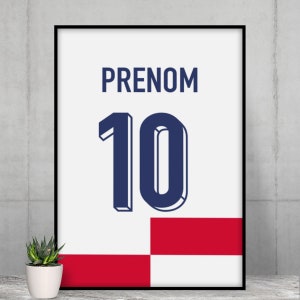 May include: A white framed poster with a blue and white number 10 and the word "PRENOM" in black text. The poster has a red and white checkered background.