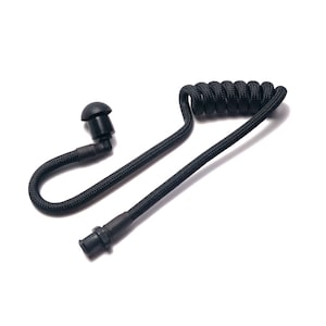 Könnte beinhalten: Schwarzer, gewendelter Ohrhörer mit einem kleinen Ohrstöpsel und einem Stecker. Das Kabel besteht aus einem gewebten Material. Der Ohrhörer ist für die Kommunikation konzipiert und wird wahrscheinlich in der Sicherheit oder Überwachung verwendet.