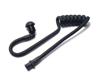 Könnte beinhalten: Schwarzer, gewendelter Ohrhörer mit einem kleinen Ohrstöpsel und einem Stecker. Das Kabel besteht aus einem gewebten Material. Der Ohrhörer ist für die Kommunikation konzipiert und wird wahrscheinlich in der Sicherheit oder Überwachung verwendet.