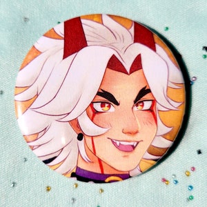 May include: A button featuring a close-up portrait of a person with white hair, red eyes, and a red and gold background. The person is smiling with sharp teeth and has a red mark on their cheek.