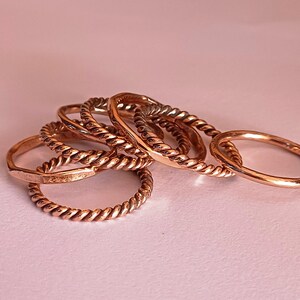 K&ouml;nnte beinhalten: Ein Satz von f&uuml;nf goldfarbenen Ringen mit einem gedrehten Seil-Design. Die Ringe sind &uuml;bereinander gestapelt.