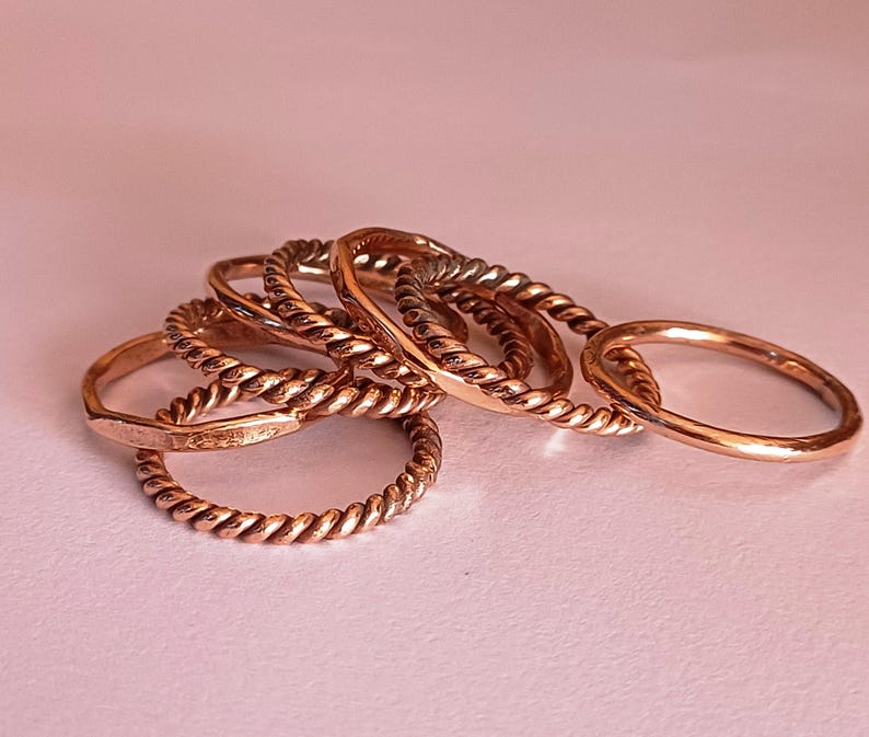 K&ouml;nnte beinhalten: Ein Satz von f&uuml;nf goldfarbenen Ringen mit einem gedrehten Seil-Design. Die Ringe sind &uuml;bereinander gestapelt.