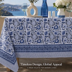 May include: A rectangular tablecloth featuring a white base with a repeating blue floral block print pattern, a wide decorative border, and a striped edge. The text "Timeless Design, Global Appeal" and "A FRESH PALETTE FOR MODERN LIVING" is visible.