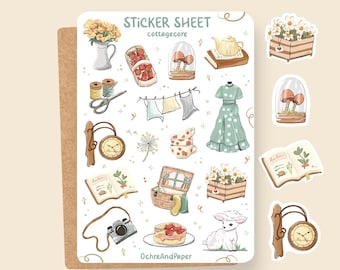 May include: A sticker sheet with a cottagecore theme featuring illustrations of a teapot, mushrooms, a dress, a clock, a book, a camera, a cake, a sheep, and flowers. The sheet is white with a brown border and the text "Sticker Sheet cottagecore OchreAndPaper" is printed at the bottom.