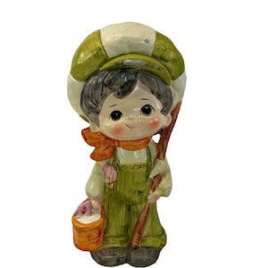 May include: A set of three ceramic mugs with a speckled, matte finish. The mugs are in shades of cream, light gray, and dark gray. Each mug has a simple, minimalist design and a rounded handle. The mugs are likely for coffee or tea.