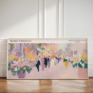 May include: A rectangular framed art print featuring an impressionist painting by Henri Matisse. The artwork displays a vibrant street scene with colourful floral arrangements, abstract figures in motion, and soft pink tones. Text reads Henri Matisse and Berggruen & Cie Paris-VII.