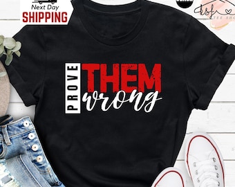 May include: Black t-shirt with the text "PROVE THEM wrong" in red and white lettering.