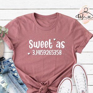 May include: A mauve t-shirt with the text "Sweet as 3.14159265358" in white with small hearts around the text.