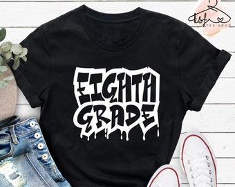 Puede incluir: Camiseta negra con texto blanco que dice "Eighth Grade" en una fuente de estilo graffiti. El texto tiene gotas que caen desde la parte inferior.