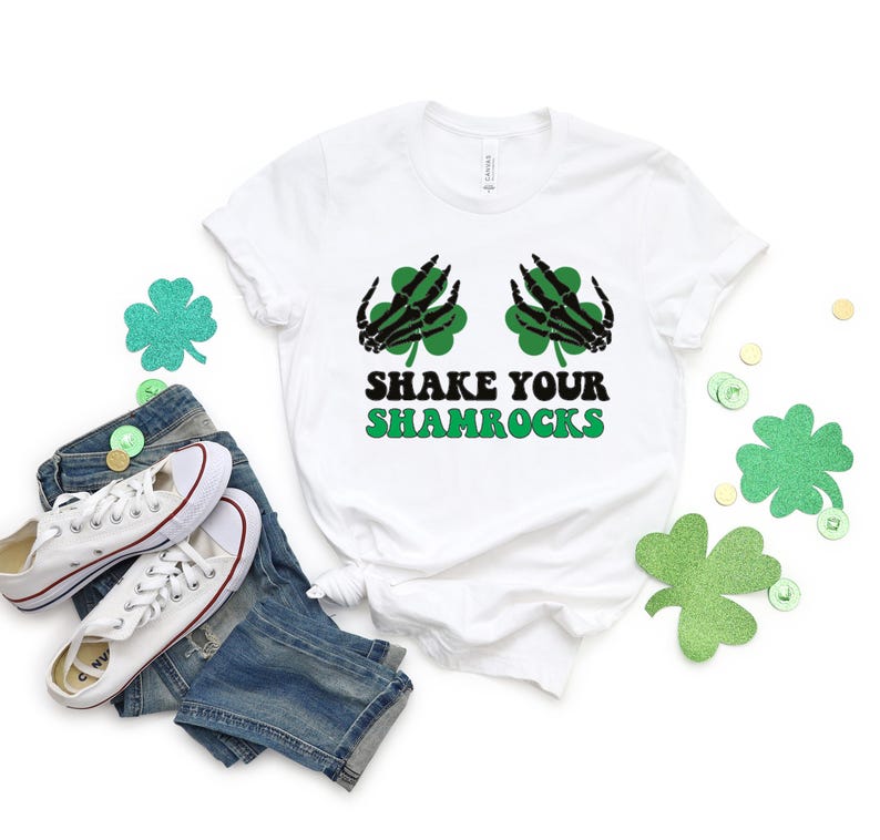 May include: White t-shirt with a green shamrock design and the text "Shake Your Shamrocks".