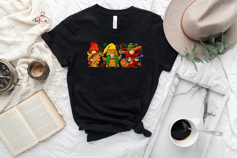 May include: Black t-shirt with a graphic of three gnomes playing musical instruments. The gnomes are wearing colorful hats and outfits.