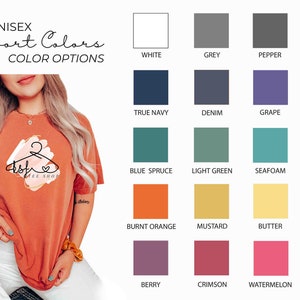 May include: An orange unisex t-shirt with a graphic design and the text "asfe tee shop". The image also displays a color chart with various options, including white, grey, black, and other colors.