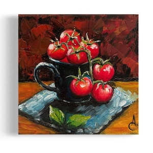 May include: A still life painting of a black ceramic mug filled with red tomatoes on a vine. The mug is sitting on a blue and white patterned napkin on a wooden table.