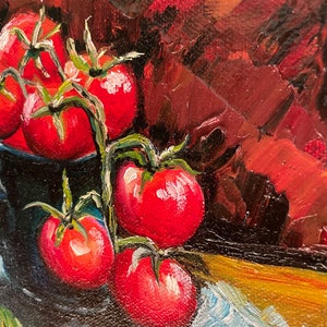 May include: A still life painting of red tomatoes on a vine in a blue bowl. The tomatoes are arranged in a cluster, with some spilling out of the bowl. The background is a dark red.