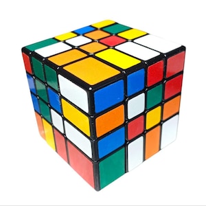 May include: A classic Rubik's Cube puzzle toy with a black frame and colorful squares in red, orange, yellow, green, blue, and white.