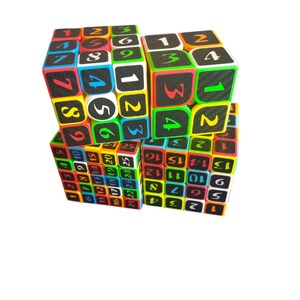 Op de afbeelding: Een veelkleurige kubuspuzzel met de nummers 1 tot en met 25 op elke zijde. De kubus is gemaakt van kleinere kubussen die kunnen worden gedraaid om de puzzel op te lossen.