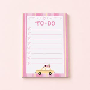 May include: A rectangular notepad featuring a pink and yellow striped border. The white center contains the text TO-DO at the top, followed by eight horizontal lines for writing. A column of stars runs down the left side, and a yellow taxi with luggage on its roof is illustrated at the bottom.