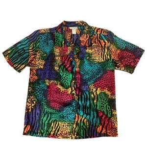 May include: A short-sleeved button-up shirt with a colorful animal print pattern. The shirt features a variety of animal prints, including zebra, leopard, and cheetah, in shades of pink, blue, green, yellow, and black.