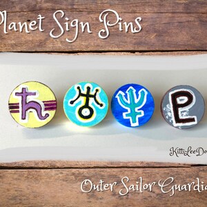 May include: Four round pins with painted planet symbols from the Sailor Moon anime. The pins are yellow, blue, blue, and gray with purple, black, white, and brown accents. The text "Planet Sign Pins" is at the top of the image and "Outer Sailor Guardians" is at the bottom.
