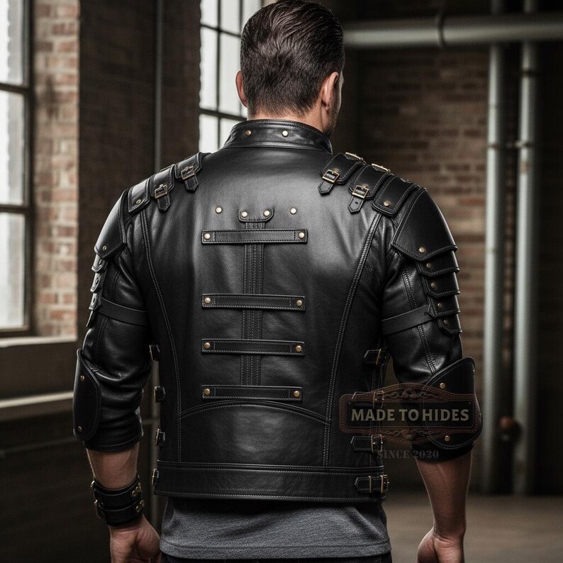 May include: Black leather jacket with multiple straps, buckles, and decorative rivets. The jacket features shoulder armor and a unique design. The back of the jacket is visible, showcasing the intricate details and craftsmanship. The jacket is a stylish piece of outerwear.