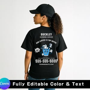 May include: A black t-shirt featuring the text "BUCKLEY CLEANING SERVICE" and a cartoon bucket graphic. The shirt also displays a phone number and website address. The person in the image is wearing a black baseball cap.