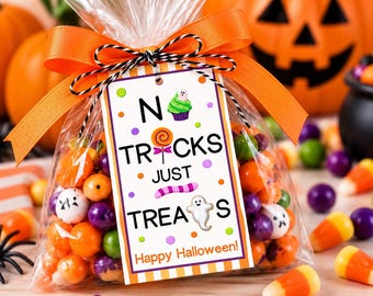 May include: A clear plastic treat bag filled with colorful candies, tied with an orange ribbon and a black and white twine bow. A rectangular tag features the text NO TRICKS JUST TREATS and Happy Halloween, decorated with a cupcake, lollipop, and ghost.