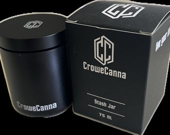Może przedstawiać: Czarny, cylindryczny pojemnik do przechowywania z srebrnym logo CroweCanna i czarne pudełko z logo CroweCanna i tekstem "Stash Jar 75 ml".