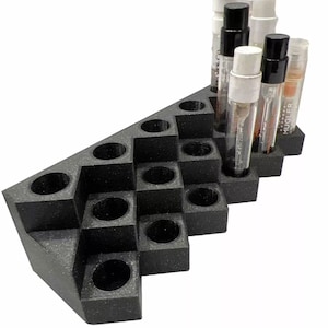 May include: Black triangular stand with 20 round holes for holding small bottles. The stand has a textured surface. Five clear glass bottles with black and white caps are in the holes.