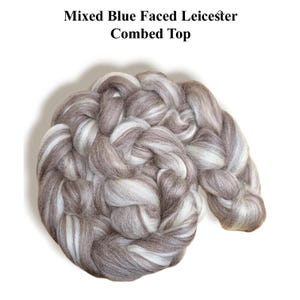 May include: A braided, mixed-color combed top of wool fiber. The fiber is a mix of gray, brown, and white. The text "Mixed Blue Faced Leicester Combed Top" is at the top of the image.