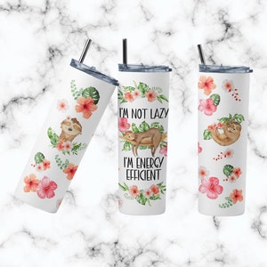 May include: White stainless steel tumbler with a pink floral pattern and a sloth design. The tumbler has the text "I'm not lazy, I'm energy efficient".