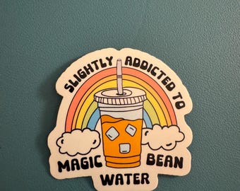 May include: A sticker featuring a cartoon iced coffee cup with ice cubes, a straw, and the words "MAGIC BEAN WATER." A rainbow arches over the cup, and the words "SLIGHTLY ADDICTED TO" are above the rainbow.