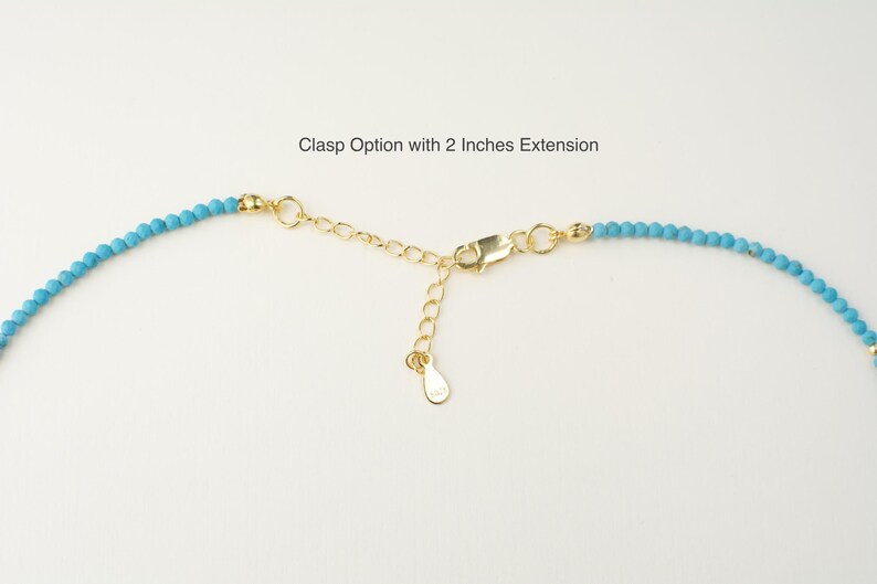 May include: Close-up of a turquoise beaded necklace with a gold clasp and a 2-inch extension chain. Clasp Option with 2 Inches Extension.