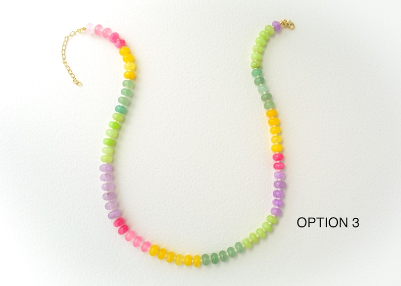 May include: A colorful beaded necklace with a gold-colored clasp. The necklace features a gradient of colors, including pink, yellow, green, and purple. The text "OPTION 3" is visible in the image.