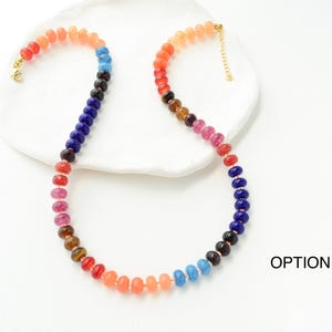 May include: A colorful beaded necklace with a gradient of colors, including red, orange, blue, and purple. The necklace has a gold clasp and is displayed on a white surface. The text "OPTION 4" is visible in the image.