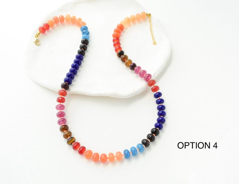 May include: A colorful beaded necklace with a gradient of colors, including red, orange, blue, and purple. The necklace has a gold clasp and is displayed on a white surface. The text "OPTION 4" is visible in the image.