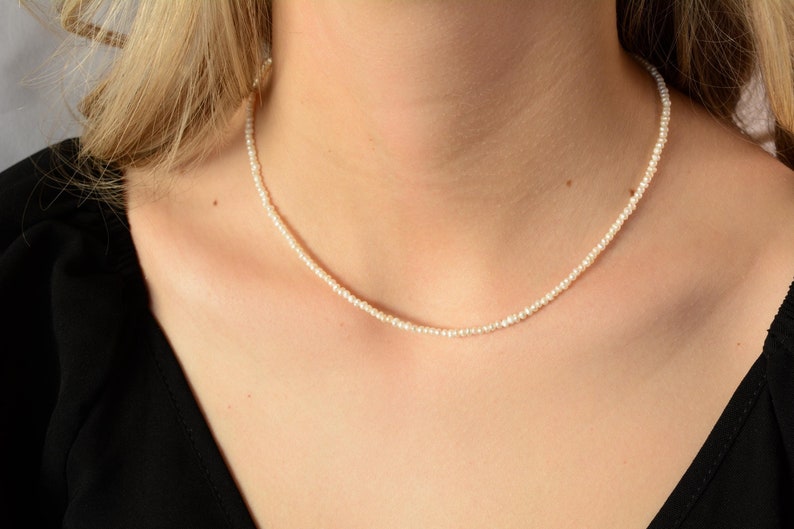 May include: A simple pearl necklace with small, white pearls. The necklace is delicate and elegant, perfect for everyday wear.