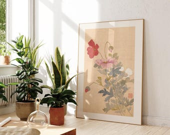 Può includere: Una stampa floreale incorniciata con fiori rossi e rosa e foglie verdi e blu. L'opera d'arte ha uno sfondo beige e una cornice dorata. La stampa è appoggiata a una parete bianca in una stanza con piante in vaso.