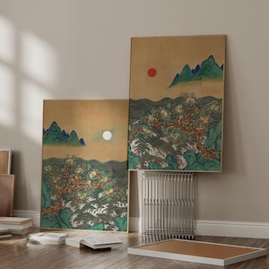 Puede incluir: Dos pinturas de paisaje enmarcadas con bordes dorados. La obra de arte representa un árbol con frutos rojos, montañas verdes y un sol rojo. El fondo es de color beige con un patrón ondulado.