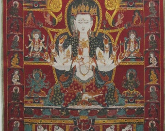 May include: A detailed, red tapestry featuring a central deity with multiple arms, surrounded by smaller figures. The artwork showcases intricate details with gold accents and a variety of colors, depicting a religious or spiritual theme. The tapestry is framed with a gold border.