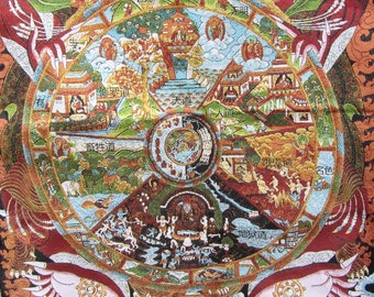 May include: A colorful tapestry with a detailed circular design depicting a Buddhist Wheel of Life. The artwork features various scenes, figures, and buildings in shades of red, green, blue, and gold, with intricate borders.