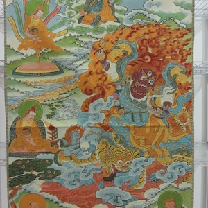 May include: A colorful tapestry depicting a religious scene with multiple figures. The central figure is a deity with a fierce expression, surrounded by flames. Other figures are seated in serene poses. The artwork features vibrant colors and intricate details.